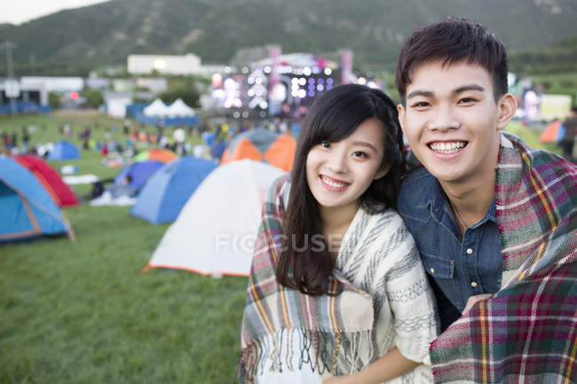 Casal chinês envolto em cobertor abraçando no festival camping — Fotografia de Stock