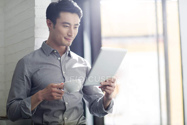 Asiatico uomo utilizzando digitale tablet in ufficio — Foto stock