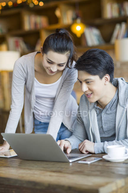 Китайська пара, використовуючи ноутбук у кафе — стокове фото