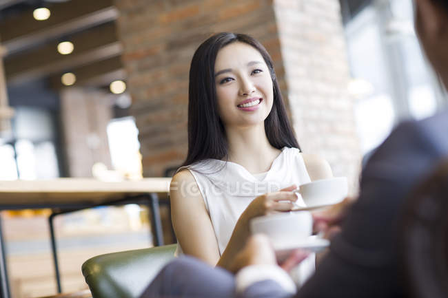 Китаянка и мужчина разговаривают в кафе — стоковое фото