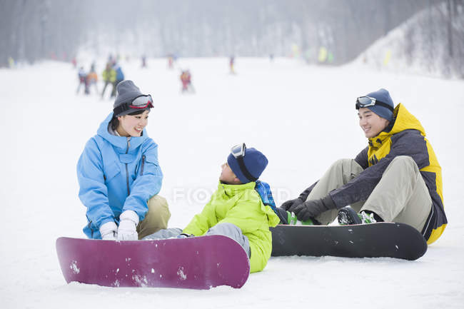 Chinese parents teaching son snowboarding — Stock Photo