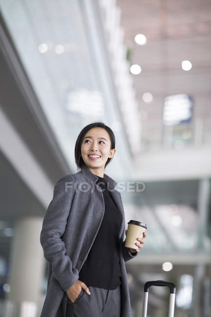 Femme asiatique en attente à l'aéroport avec café — Photo de stock