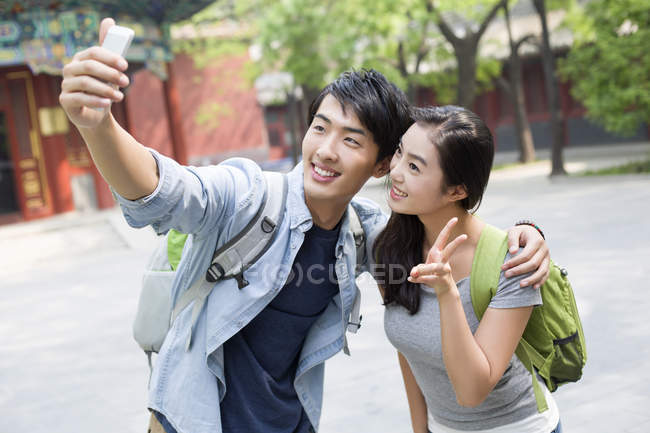 Casal chinês tirando selfie com smartphone na rua — Fotografia de Stock
