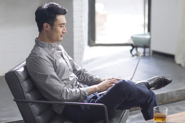 Asiatique homme travaillant avec ordinateur portable dans le bureau — Photo de stock
