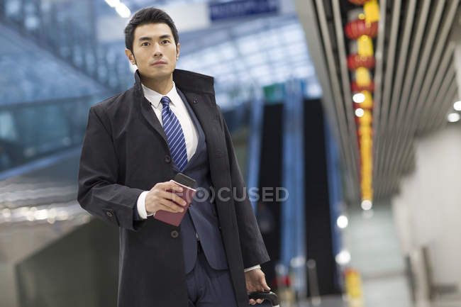 Китайський бізнесмен, ходити в аеропорту з валізу і паспорт — стокове фото