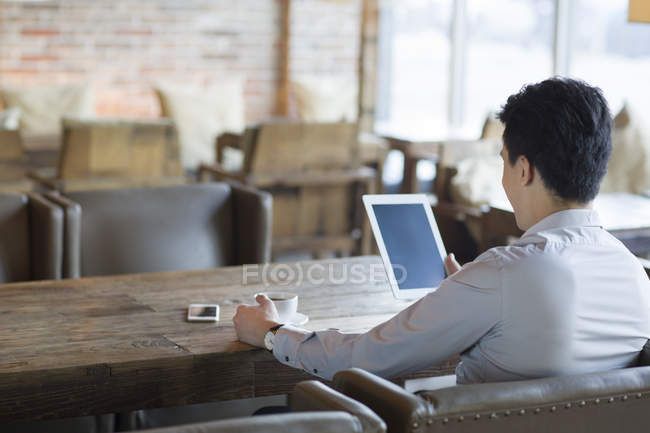 Uomo cinese che utilizza tablet digitale in caffè — Foto stock