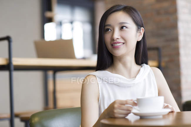 Китайська жінка, що п'ють кави в кафе — стокове фото