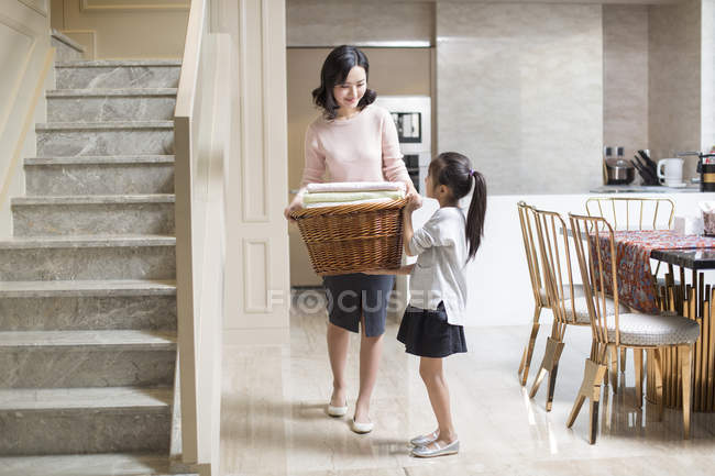 Chinese daughter helping mother doing laundry at home — Stock Photo
