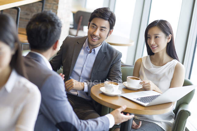 Asian business people having meeting in cafe — Stock Photo