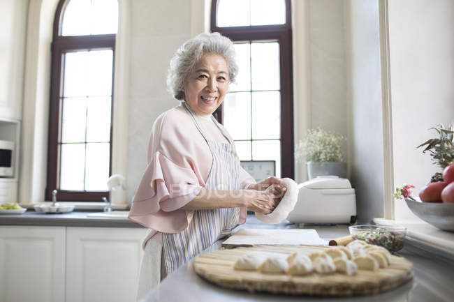 Senior donna cinese che fa gnocchi in cucina — Foto stock
