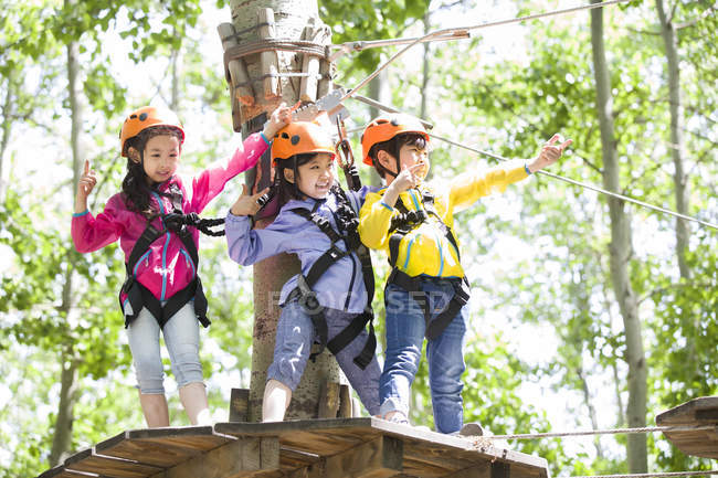 Enfants chinois posant dans le parc d'aventure haut de l'arbre — Photo de stock
