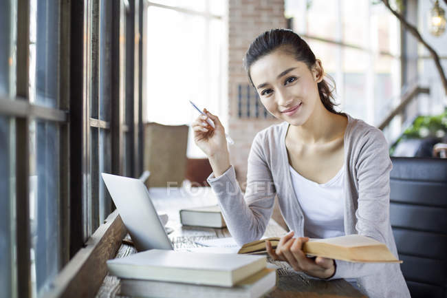 Chinese woman studying in cafe — Stock Photo