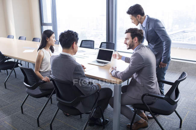 Homme d'affaires montrant la présentation sur ordinateur portable dans la salle de réunion — Photo de stock