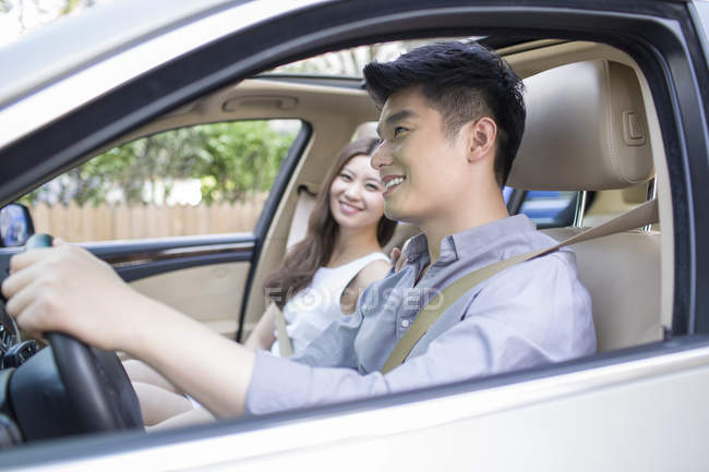 Chinese couple riding in car — Stock Photo