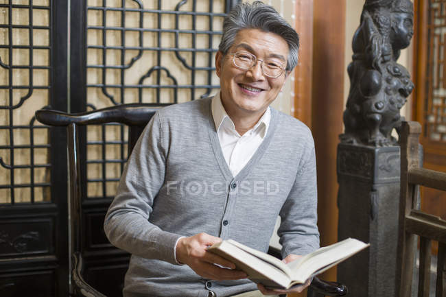 Ritratto di anziano asiatico uomo lettura libro — Foto stock