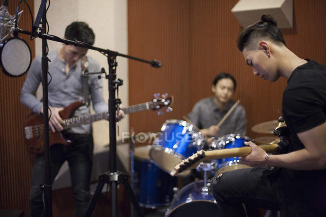Chinese musical band recording song in studio — Stock Photo
