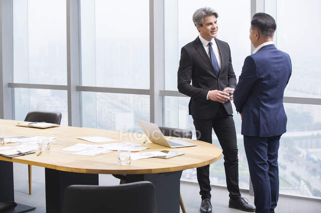Uomini d'affari che parlano in sala riunioni — Foto stock