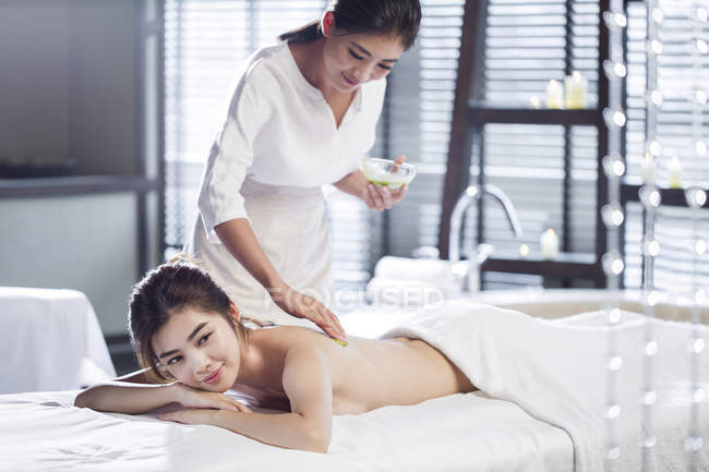Joven mujer china recibiendo masaje en el centro de spa - foto de stock