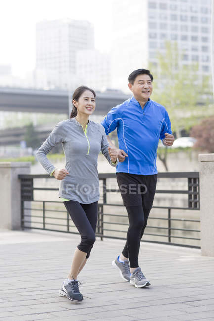 Зрелая китайская пара бегает в парке — стоковое фото