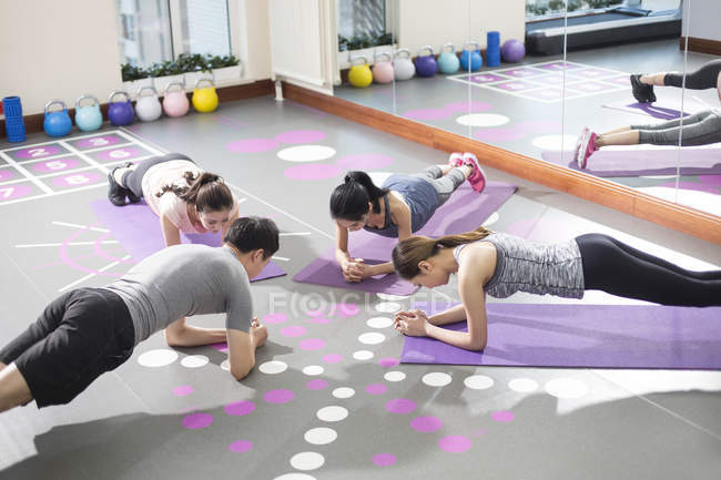 Asiatinnen arbeiten mit Trainerin im Fitnessstudio — Stockfoto