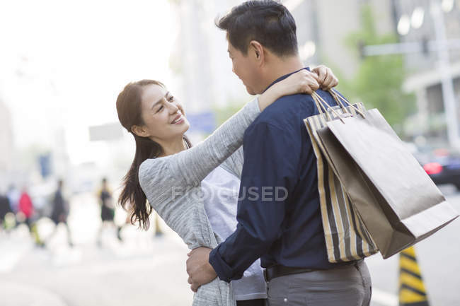 Mature chinese couple shopping in city — Stock Photo