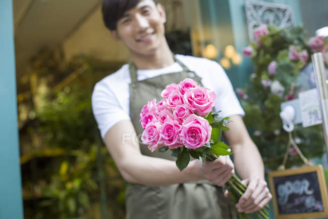Floristería china sosteniendo ramo de flores - foto de stock