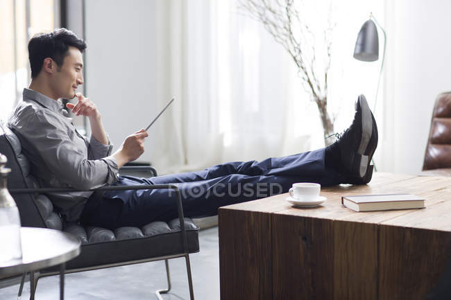 Азиатский человек с помощью цифрового планшета в офисе — стоковое фото