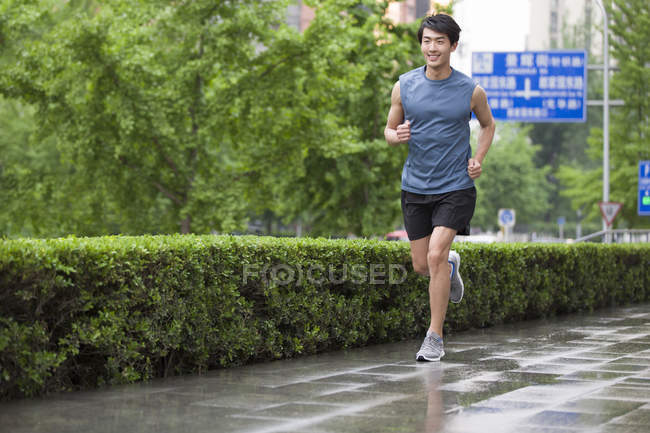 Homem chinês correndo na rua — Fotografia de Stock
