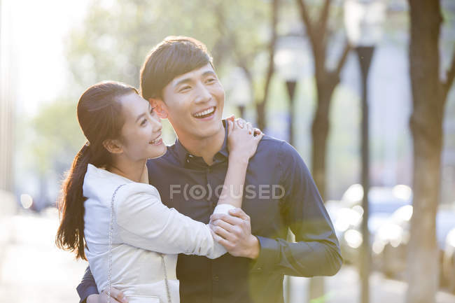 Chinese couple embracing on street — Stock Photo
