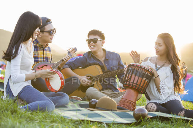 Chinese friends playing music instruments at music festival — Stock Photo