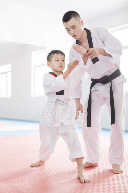 Chinese instructor teaching boy Taekwondo — Stock Photo