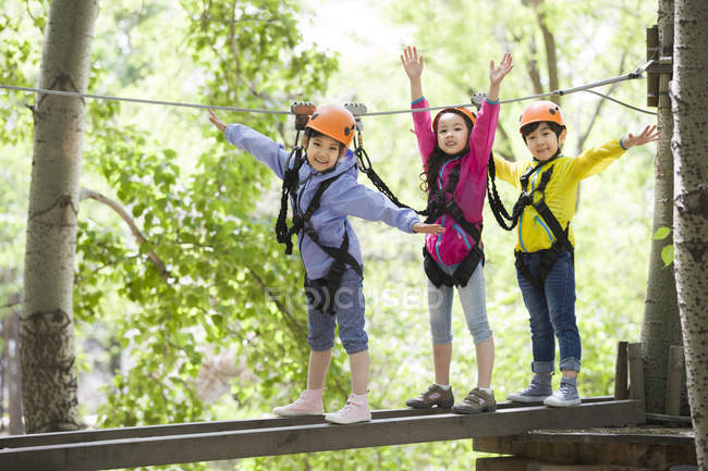 Chinese children posing in tree top adventure park — Stock Photo