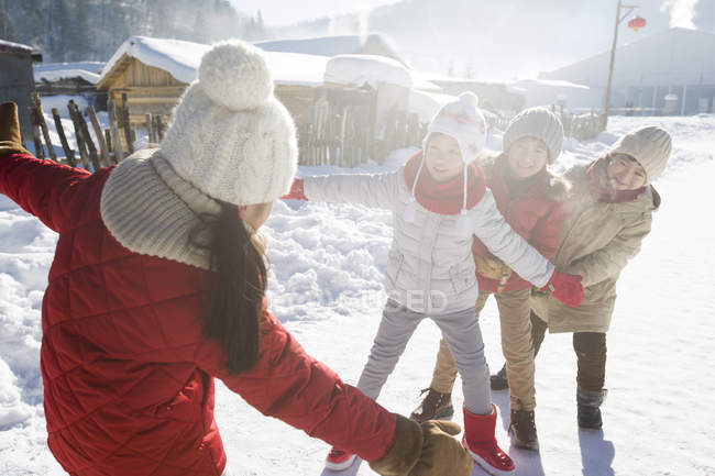 Crianças chinesas da idade elementar brincando na neve na aldeia — Fotografia de Stock
