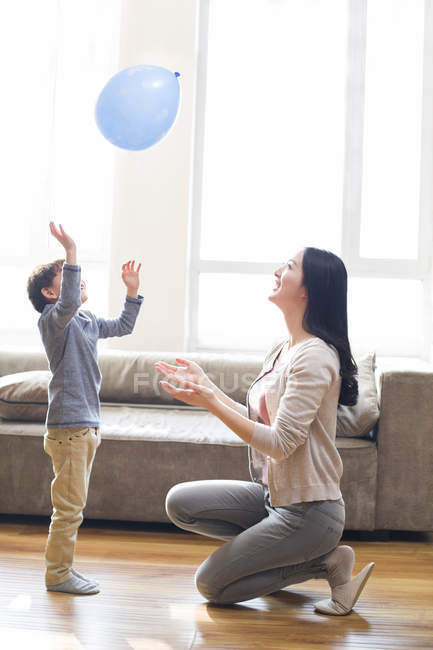 Asiática madre e hijo jugando con globo - foto de stock