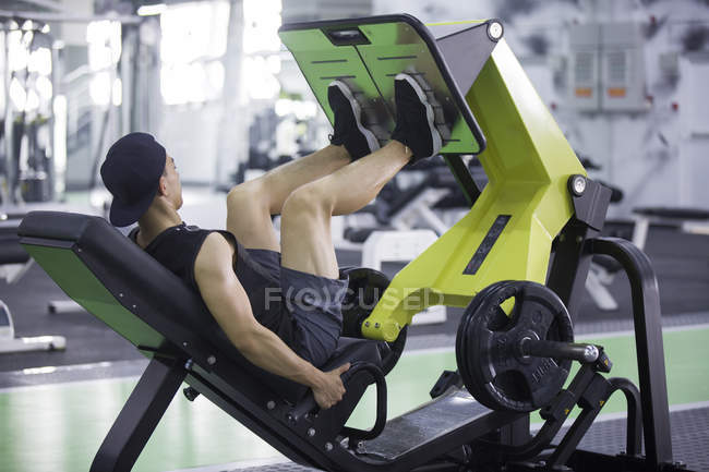 Ásia homem exercitando no ginásio — Fotografia de Stock
