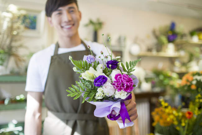 Male chinese florist holding bouquet of flowers — Stock Photo