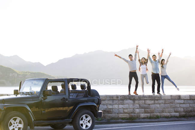 Chinese friends posing on lakeside in suburbs — Stock Photo