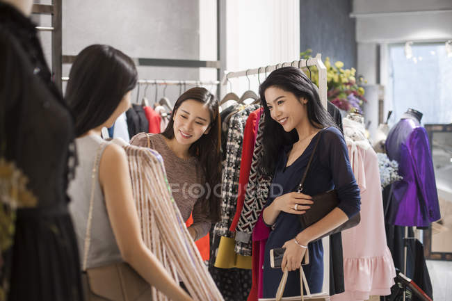 Chinese female friends shopping in clothing store — Stock Photo