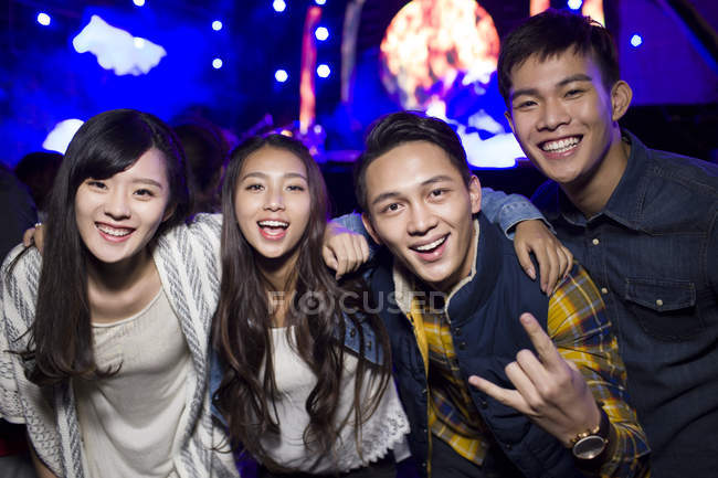Amigos chinos abrazando y haciendo gestos en el festival de música - foto de stock