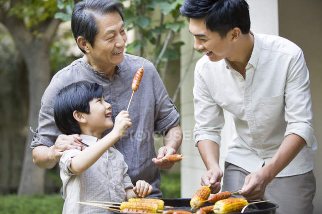 Chinesische männliche Mehrgenerationenfamilie grillt im Hof — Stockfoto