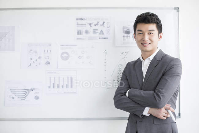 Homme d'affaires chinois debout devant le tableau blanc — Photo de stock