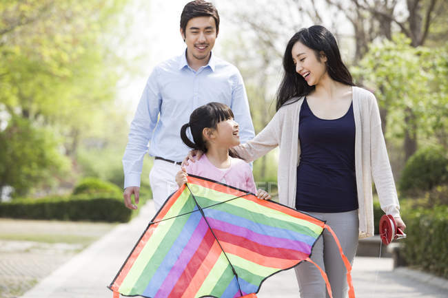 Asian family flying kite in city park — Stock Photo