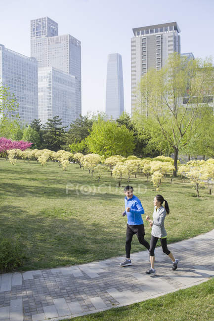 Maduro chino pareja jogging en parque - foto de stock