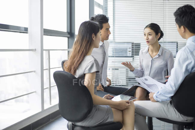 Chinese business team sitting and talking in meeting — Stock Photo