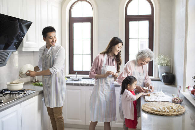 Família chinesa fazendo bolinhos na cozinha — Fotografia de Stock