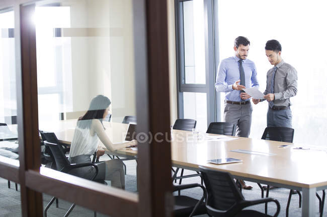 Gente de negocios discutiendo documentos en la oficina - foto de stock