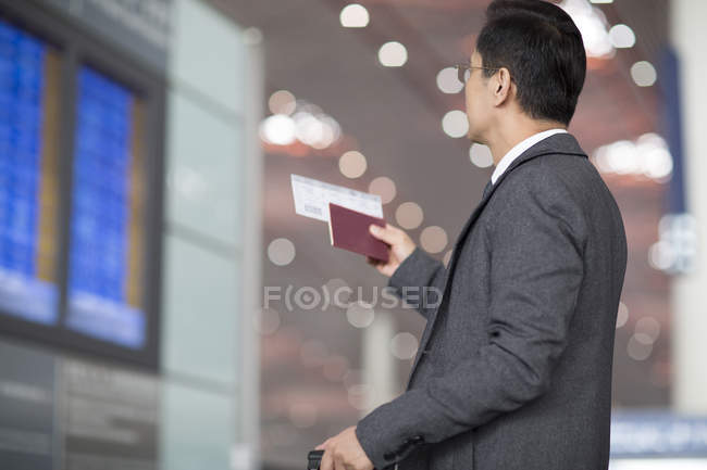 Азиатский бизнесмен с паспортом и билетом на самолет — стоковое фото
