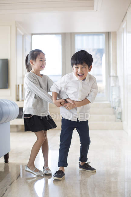 Chinese siblings playing in living room — Stock Photo