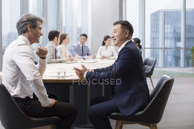 Team d'affari cinese che si incontra con partner stranieri in sala riunioni — Foto stock