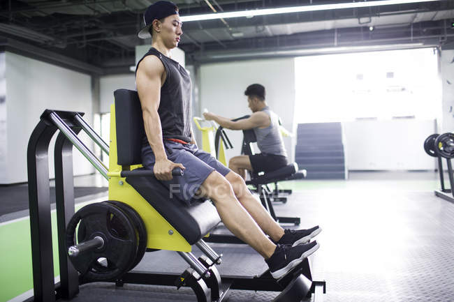 Los hombres asiáticos haciendo ejercicio en el gimnasio - foto de stock